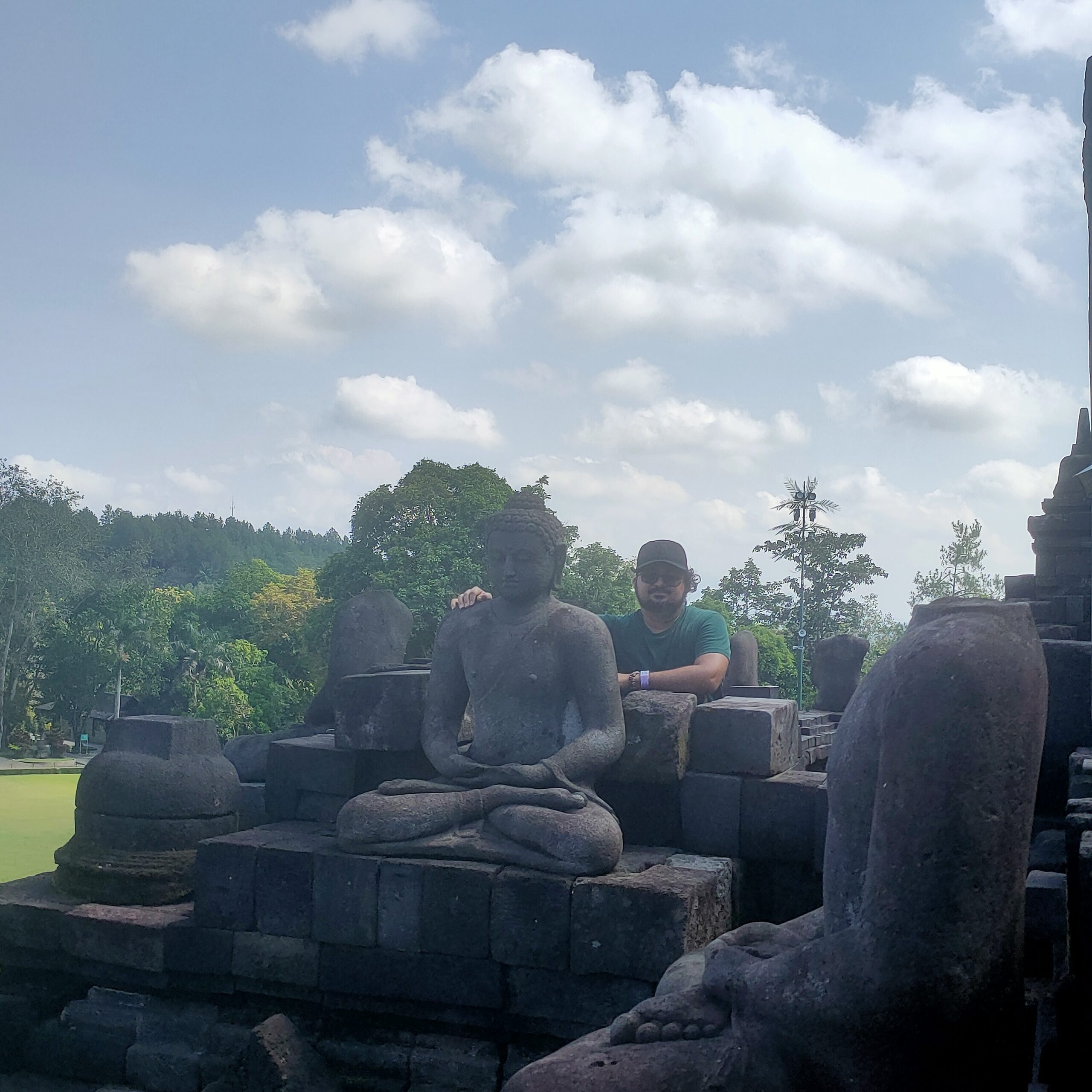 Borobudur temple Buddha statue on upper terrace with clouds April 2026