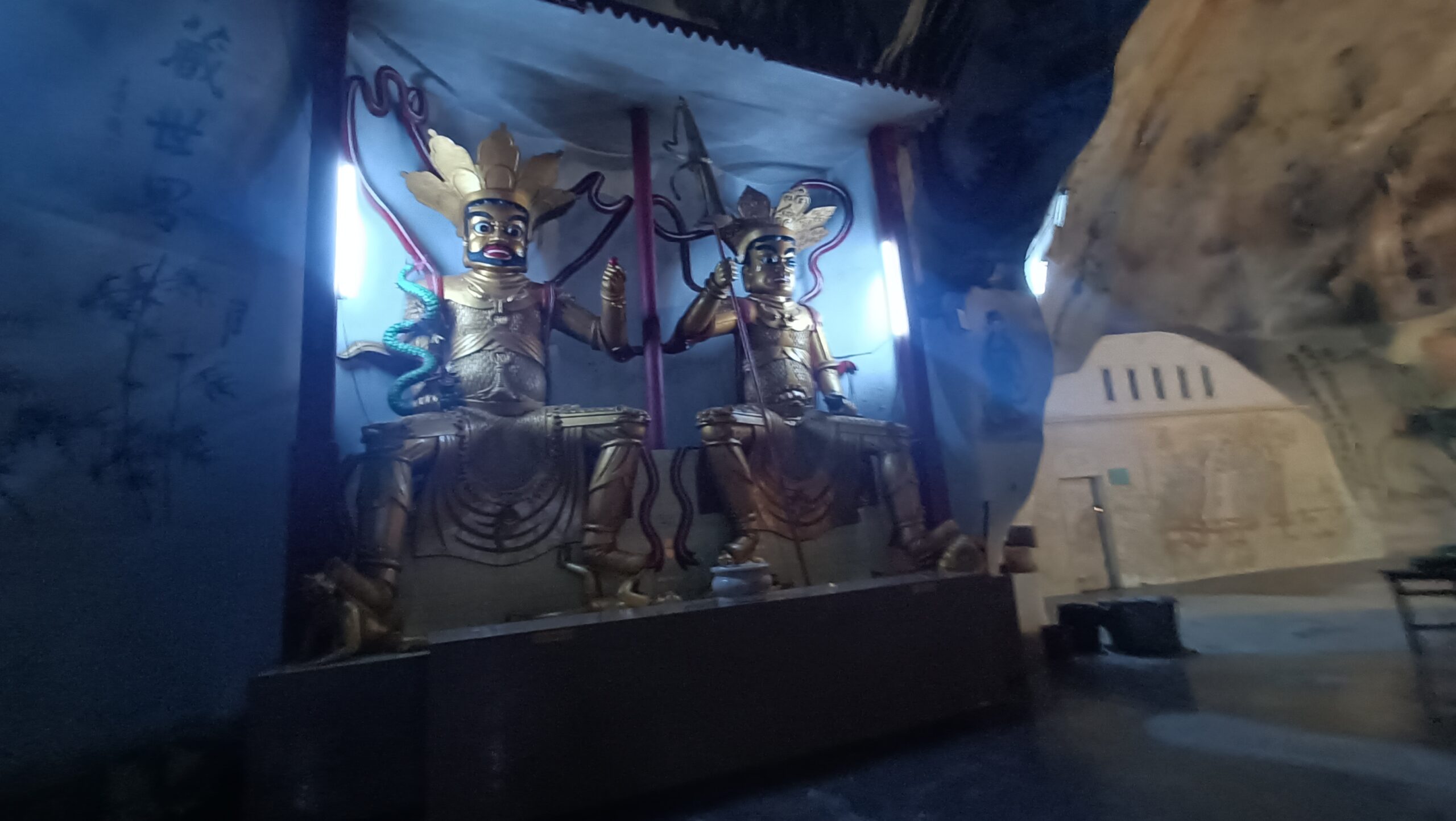 Two golden guardian deity statues inside Perak Tong Cave Temple