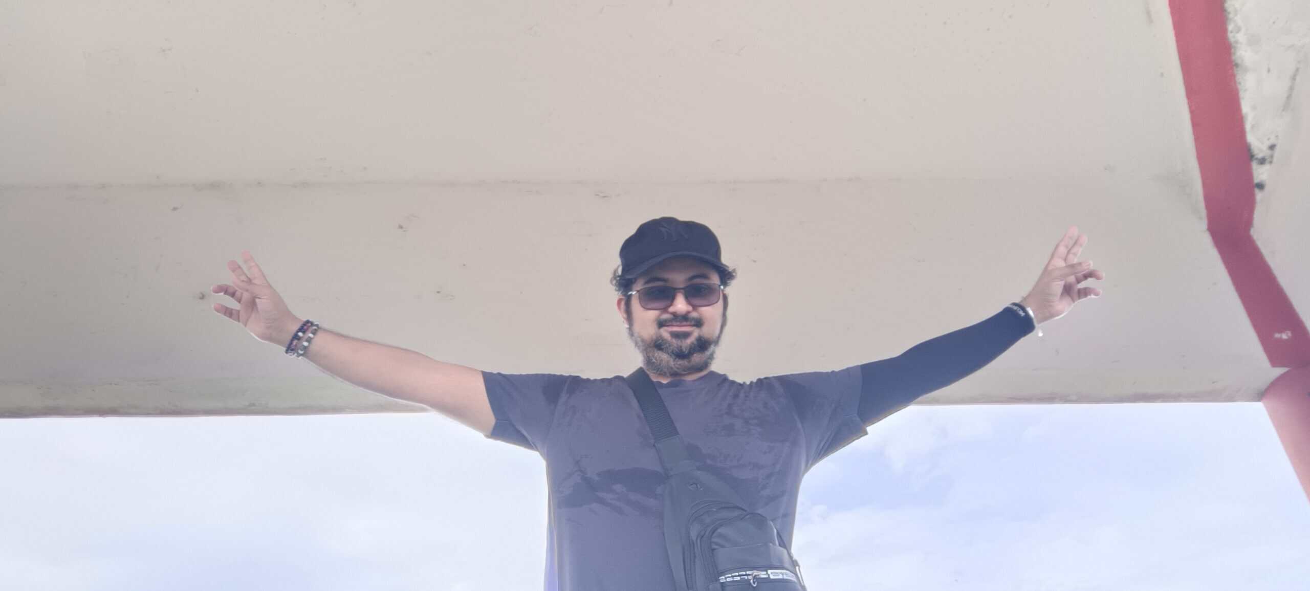 MK with arms open like wings standing under a pavilion at Perak Tong Cave Temple