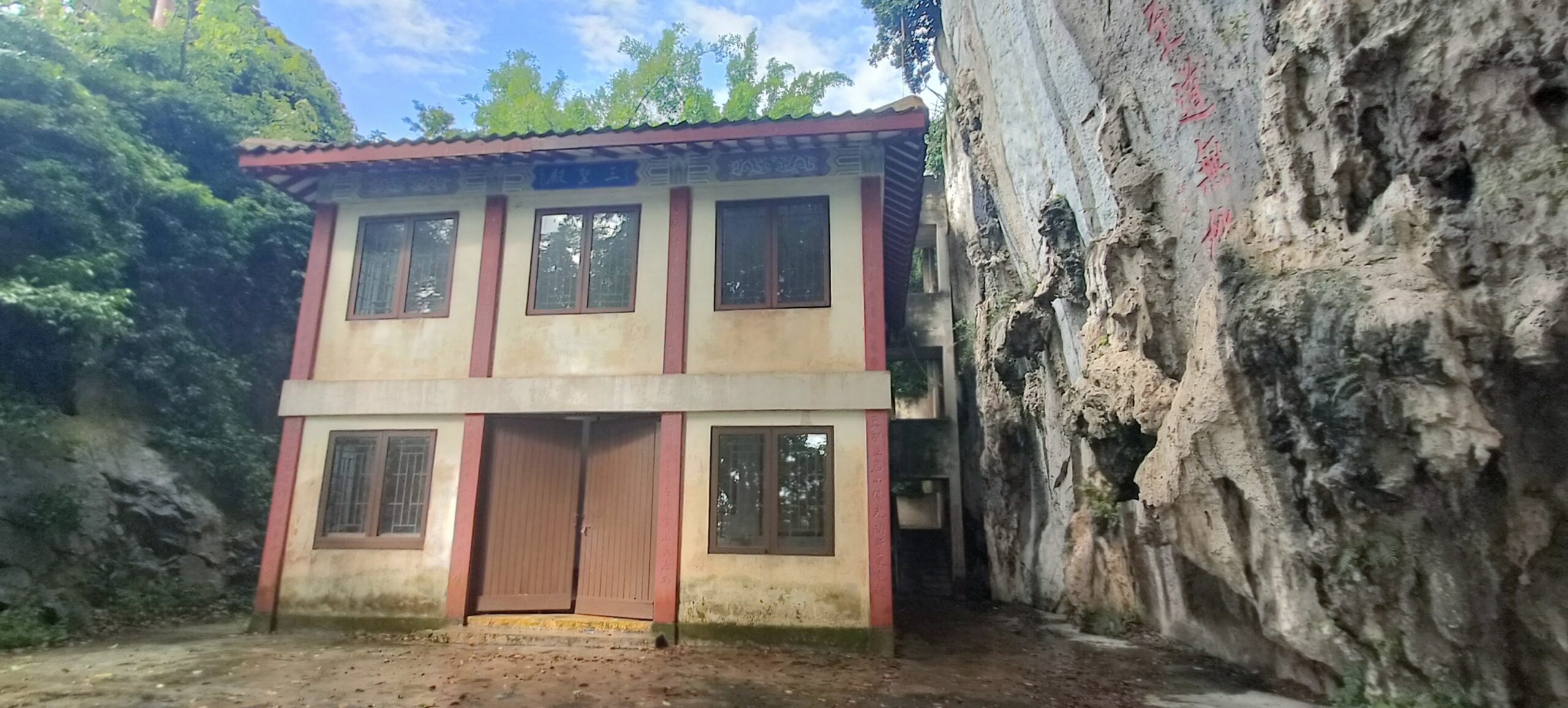 Two-story temple building next to a limestone cliff at Perak Tong Cave Temple
