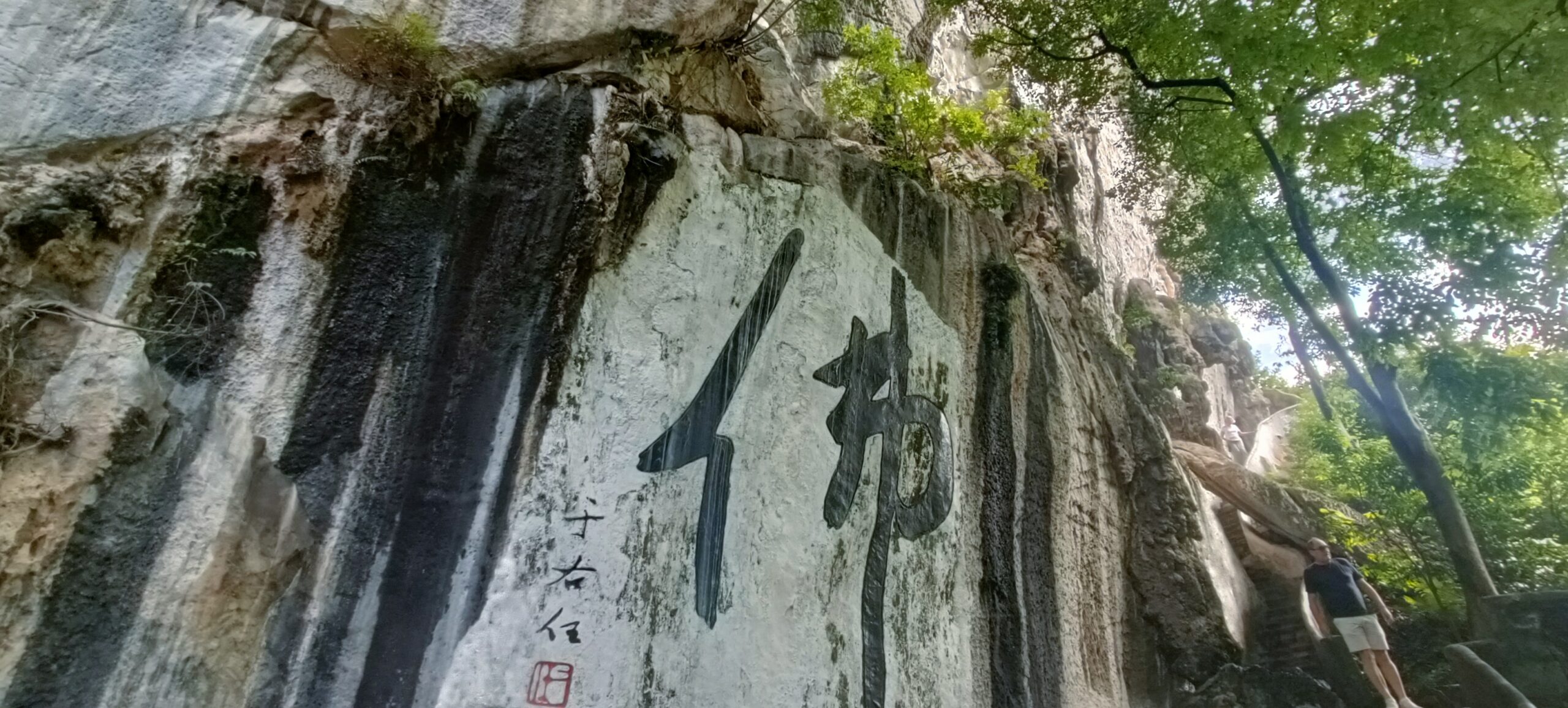 Large Chinese calligraphy characters painted on a limestone cliff at Perak Tong Cave Temple in Ipoh