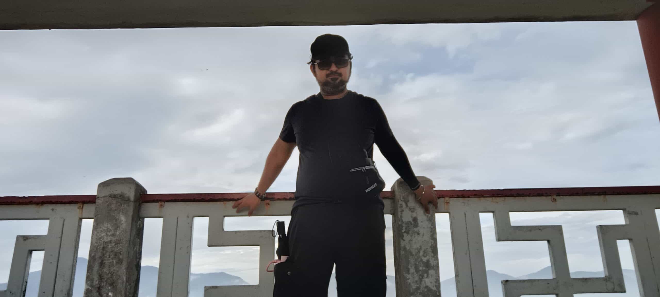 MK standing by railing with panoramic Ipoh city view behind at Perak Tong Cave Temple peak